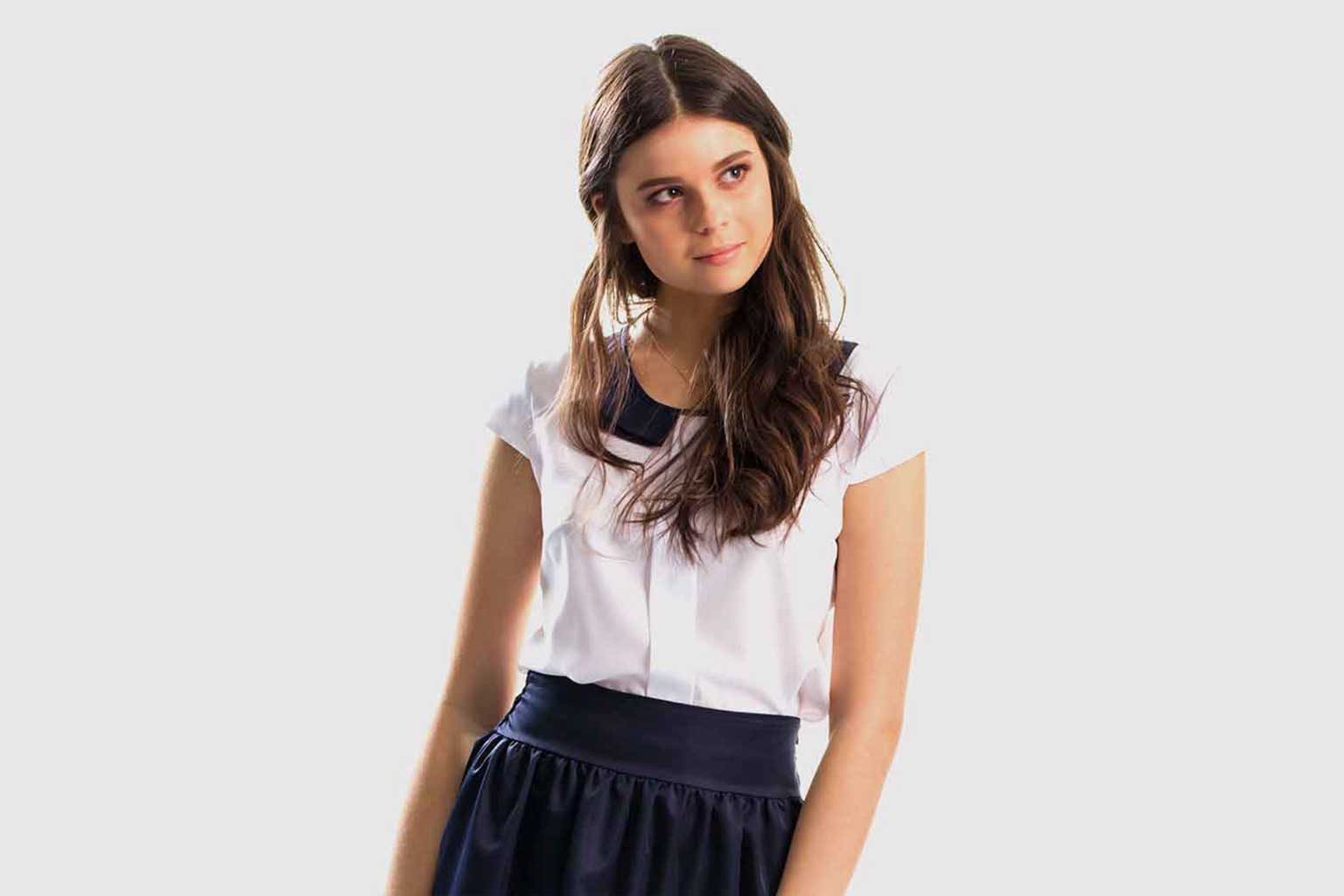 Customer wearing a tailored blouse and navy skirt after alteration