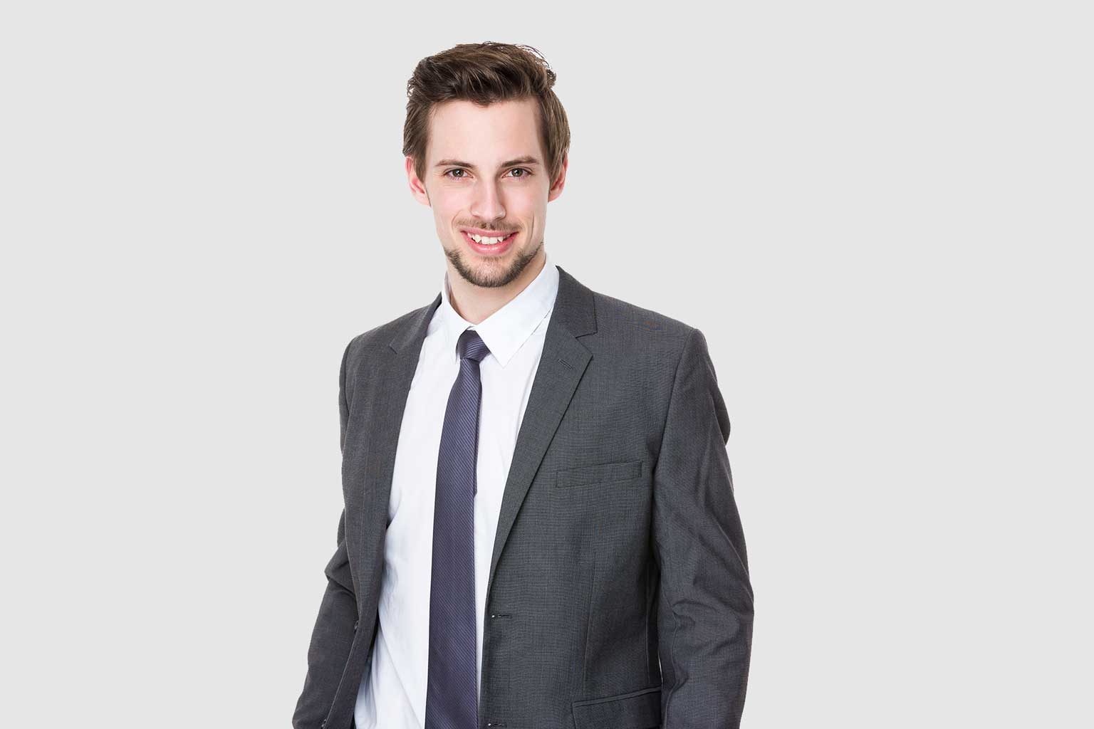 Customer in a grey suit and tie fitted by our tailors