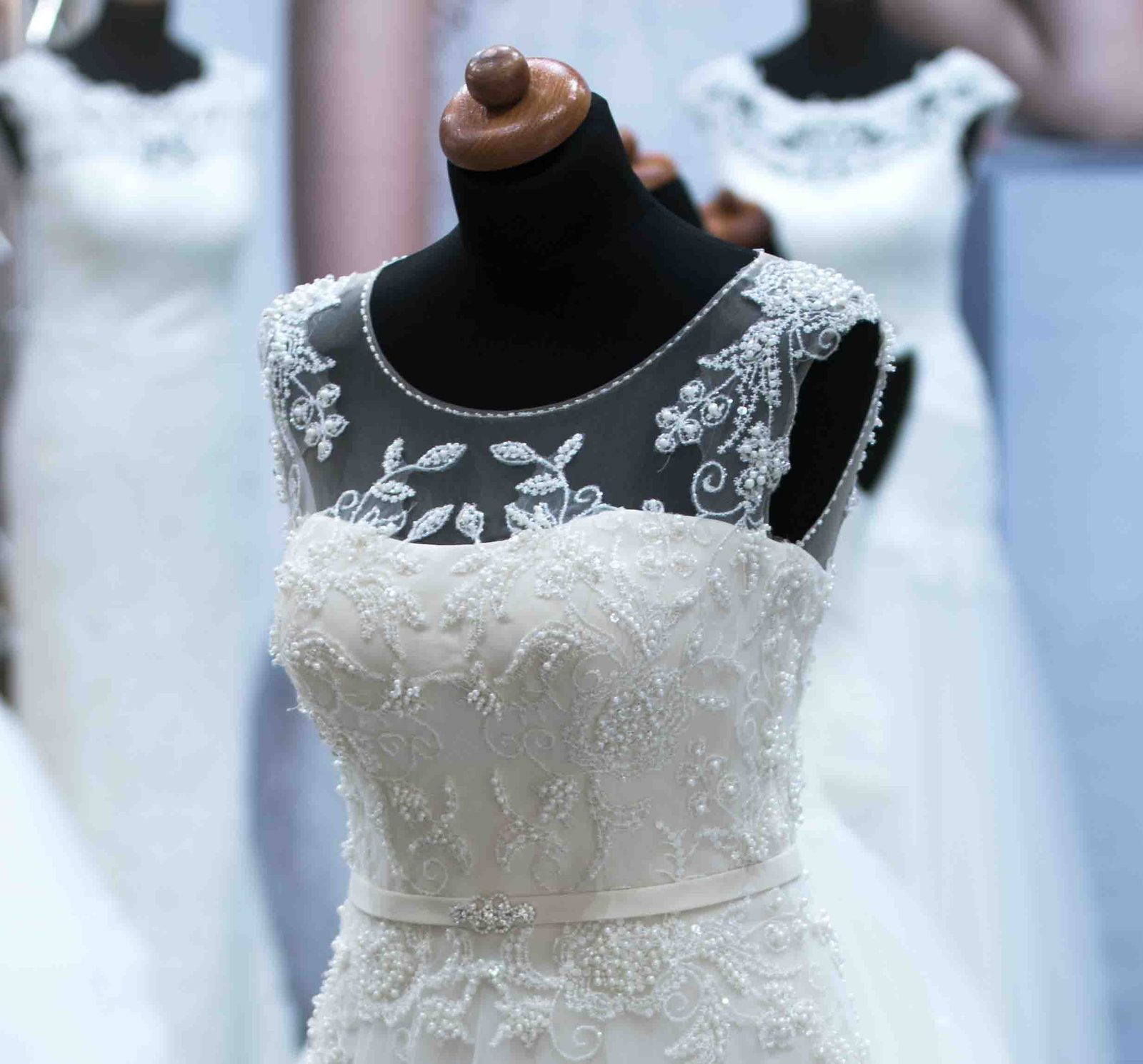Beaded lace wedding gown on a dress form being fitted for alterations